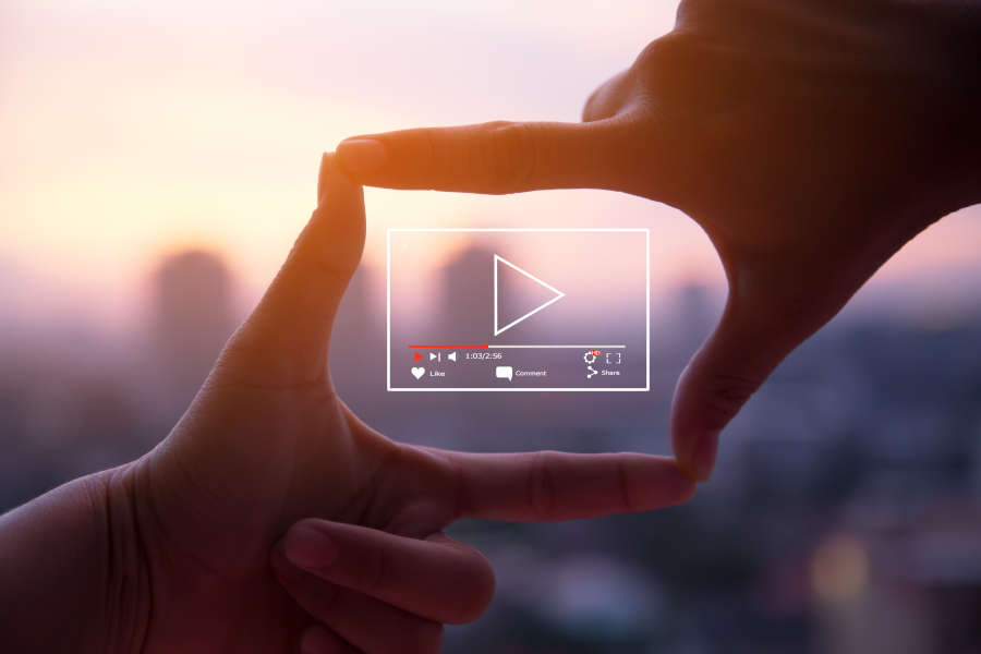 Hands making a square around a video marketing icon of a video playing