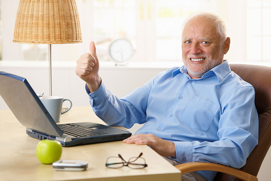 Old man on the computer with his thumb up looking at a website for a small business in Central IL