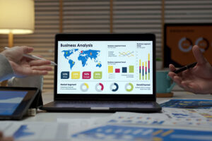 Two digital marketing experts looking at a small business’ website analytics in Terre Haute, IN with data sheets on a table.