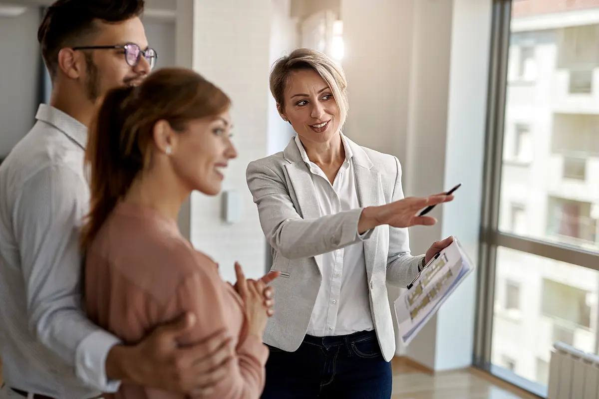 real estate agent showing a young couple an apartment for rent.