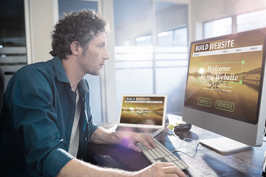 A Collinsville, IL business owner sitting in front of a computer building a new website for his business.