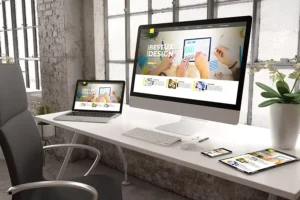 Right Click Digital, Inc.—An office set up with a desk, chair, computer, laptop, iPad, and phone, showing quality website design on each screen for a St. Louis, MO client.