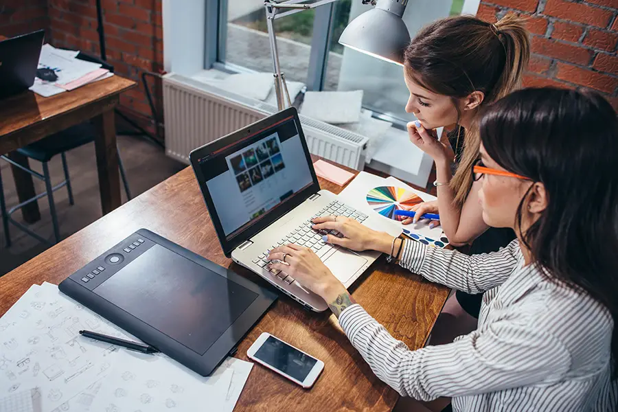 Right Click Digital—Two women in an office posting content for their company’s website in Edwardsville, IL