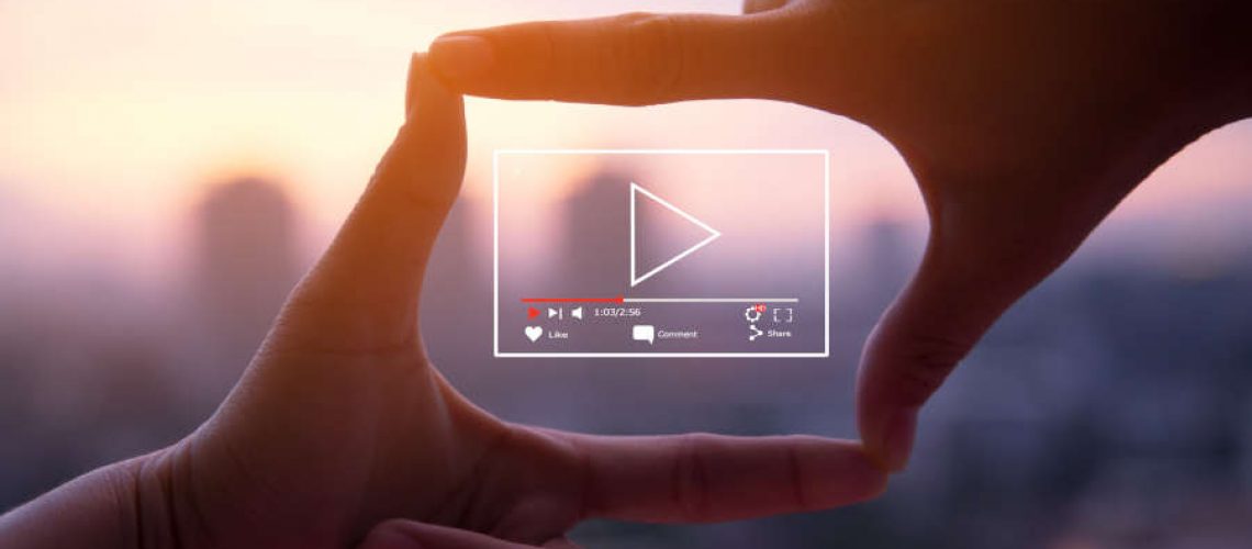 Hands making a square around a video marketing icon of a video playing